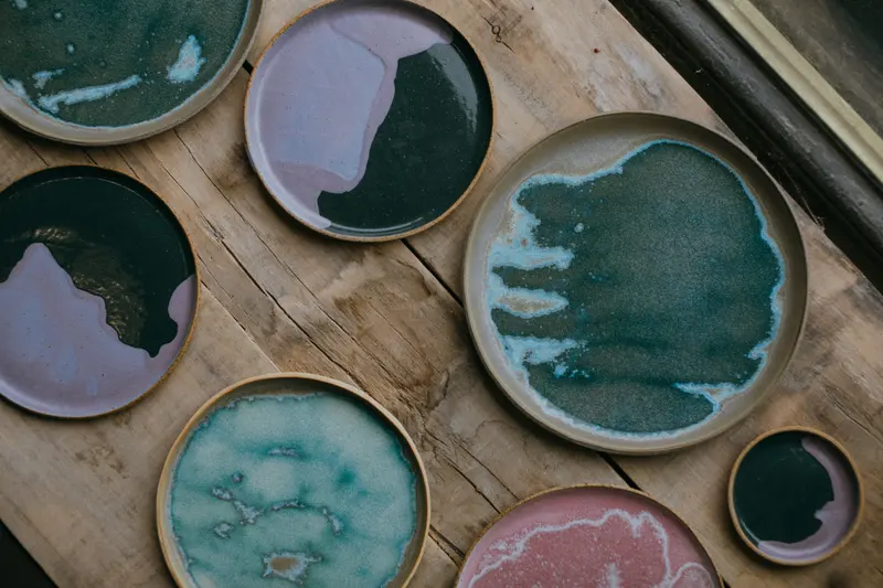 Handmade plates with varied glaze patterns, the kind of result a glaze chart combination aims for.