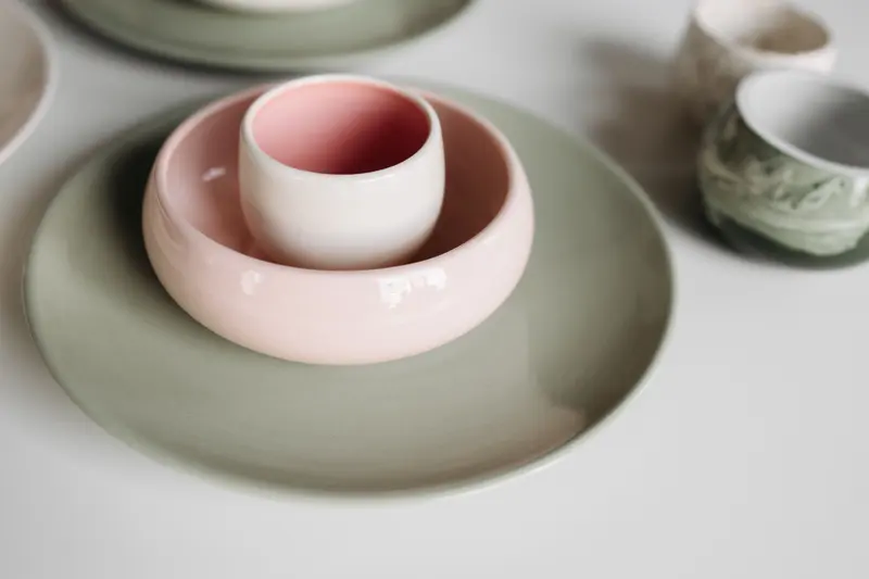 Pink and grey glazed bowls nested together, soft colours of the kind a Mason stain chart helps you mix.
