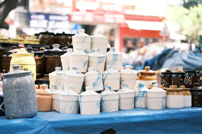 Ceramic pots on an outdoor market stall, where pottery pricing has to match what a shop would charge.