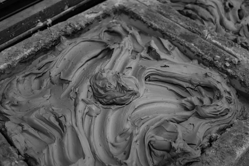 Black and white close-up of wet, swirled clay in a mould.
