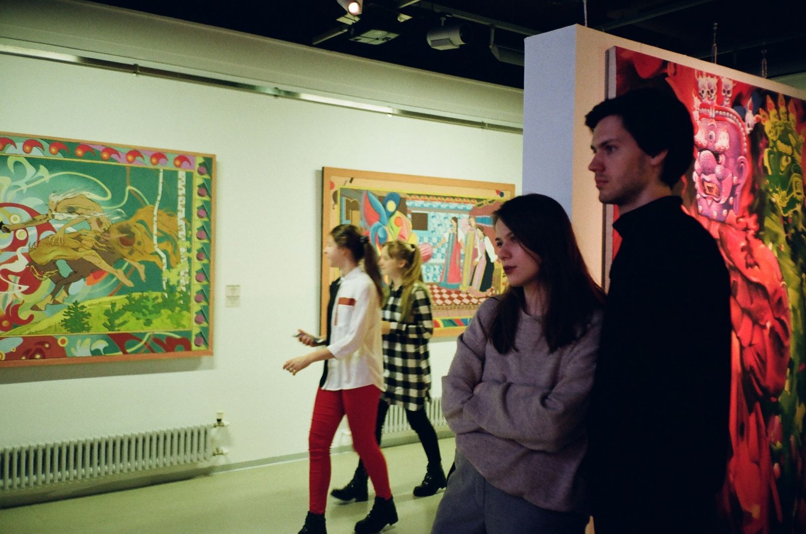 Visitors viewing paintings at a small gallery exhibition
