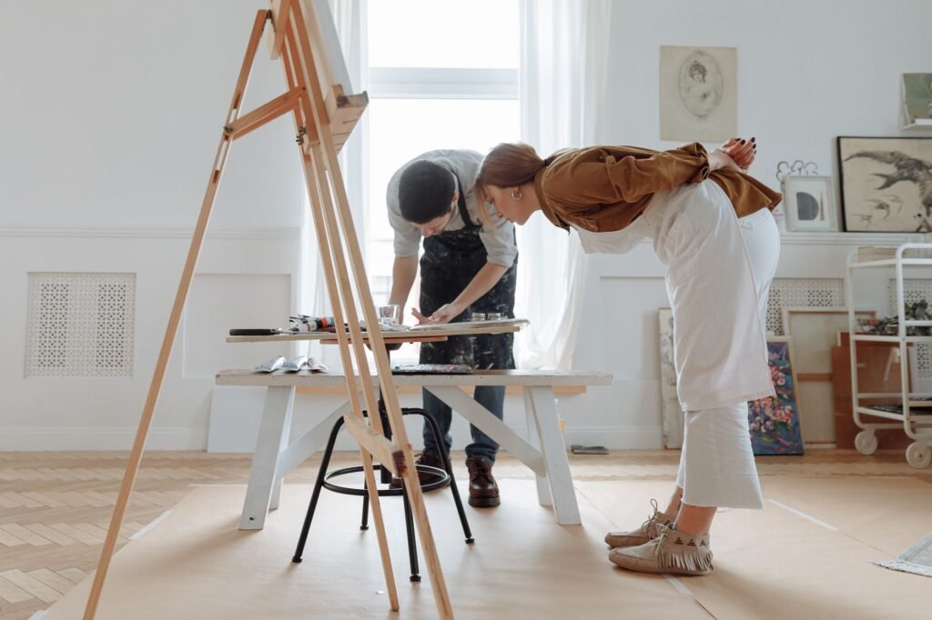 Two artists working together in a bright shared studio