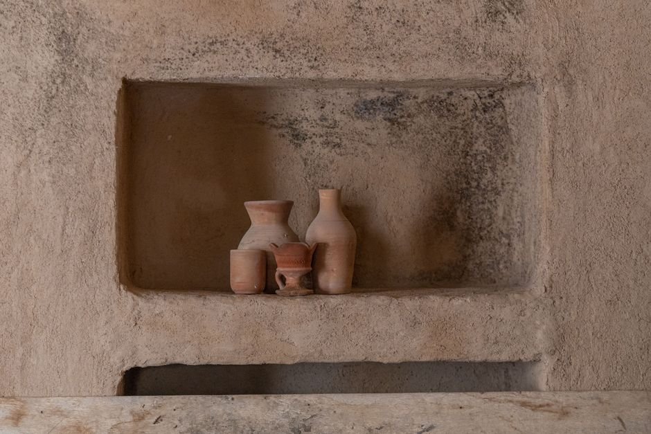 Rustic clay pottery displayed with layered Amaco Potter's Choice glaze finishes on a textured studio shelf
