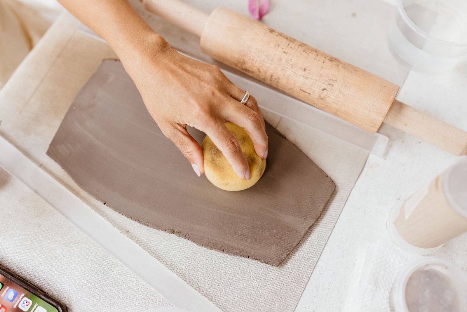 Carved wooden pottery stamp pressed into soft clay