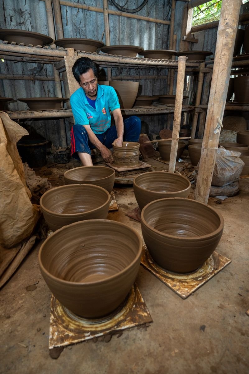Potter trimming a clay bowl with a Kemper tool
