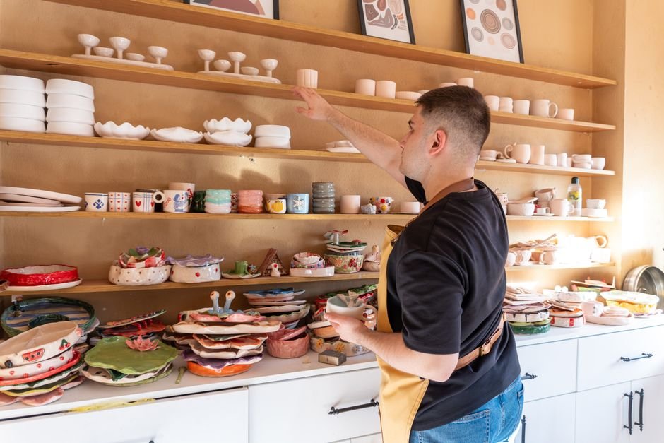 Colourful glazed ceramic dishes arranged on studio shelves showing Amaco Potter's Choice finishes
