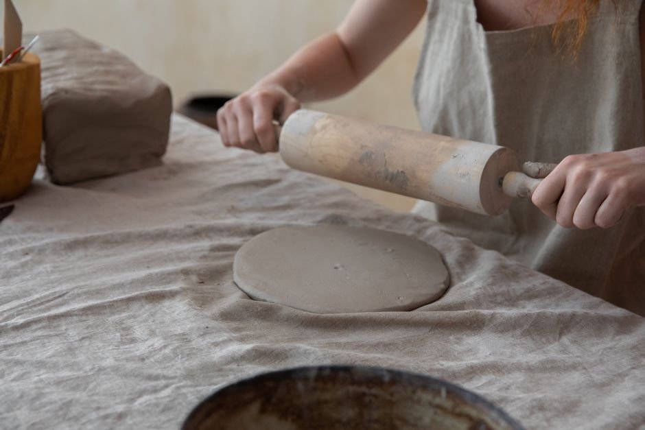 Beginner rolling an even clay slab in preparation for a GR Form