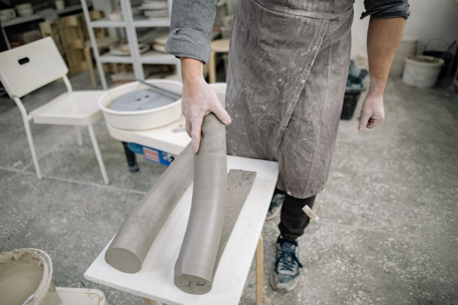 Wedging clay by hand on a studio table