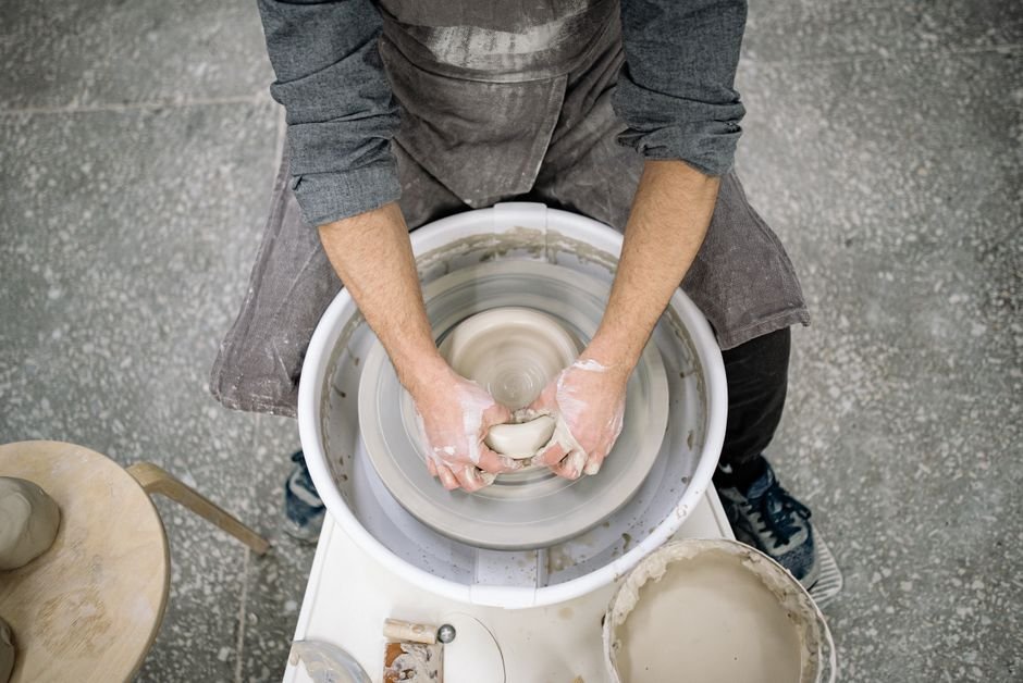 Potter centering a ball of Amaco stoneware clay on the wheel