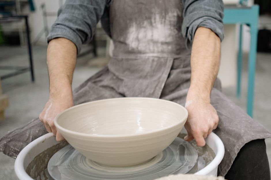 Potter using a Mudworks trimming tool to refine the foot of a bowl
