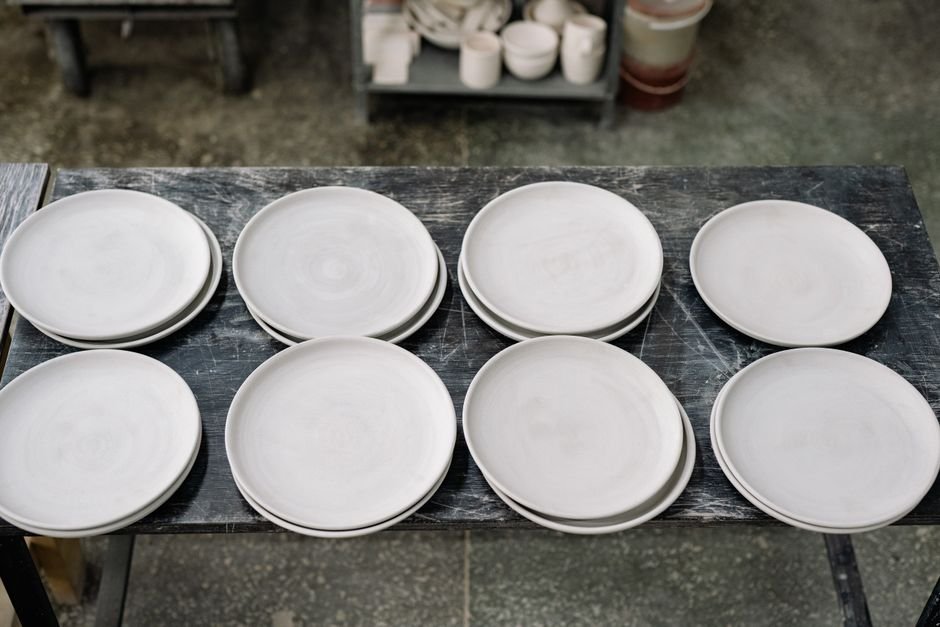 Kiln shelf with ceramic pieces prepared with catch plates for glaze firing