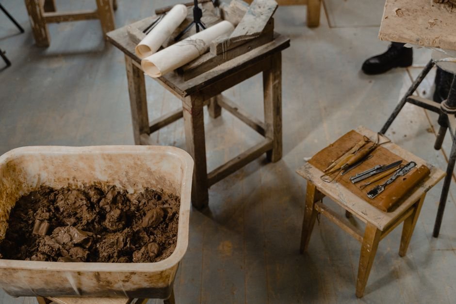 Overhead view of a craft studio table with clay and tools