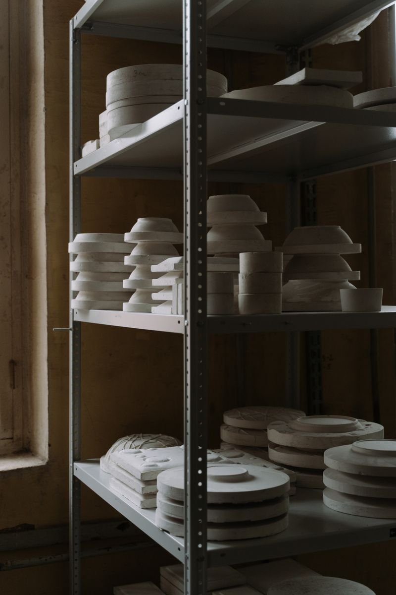 Plaster pottery molds stacked on a studio shelf