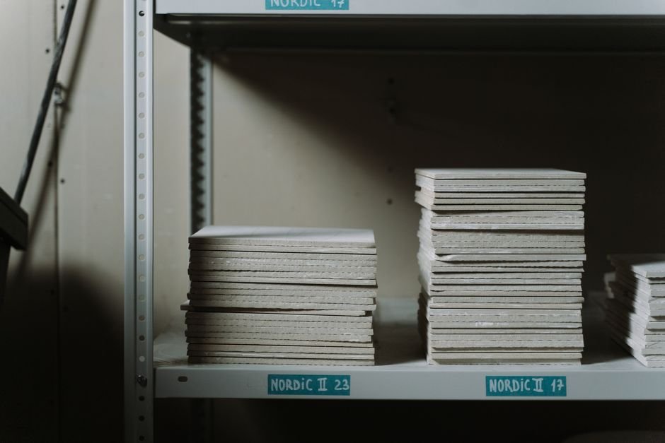 Shelves of glaze and clay supplies at a ceramics supplier warehouse