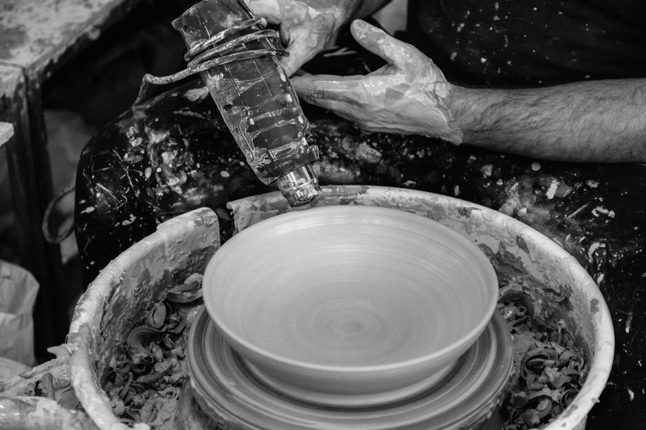 Artisan using a heat tool to shape pottery on a spinning wheel