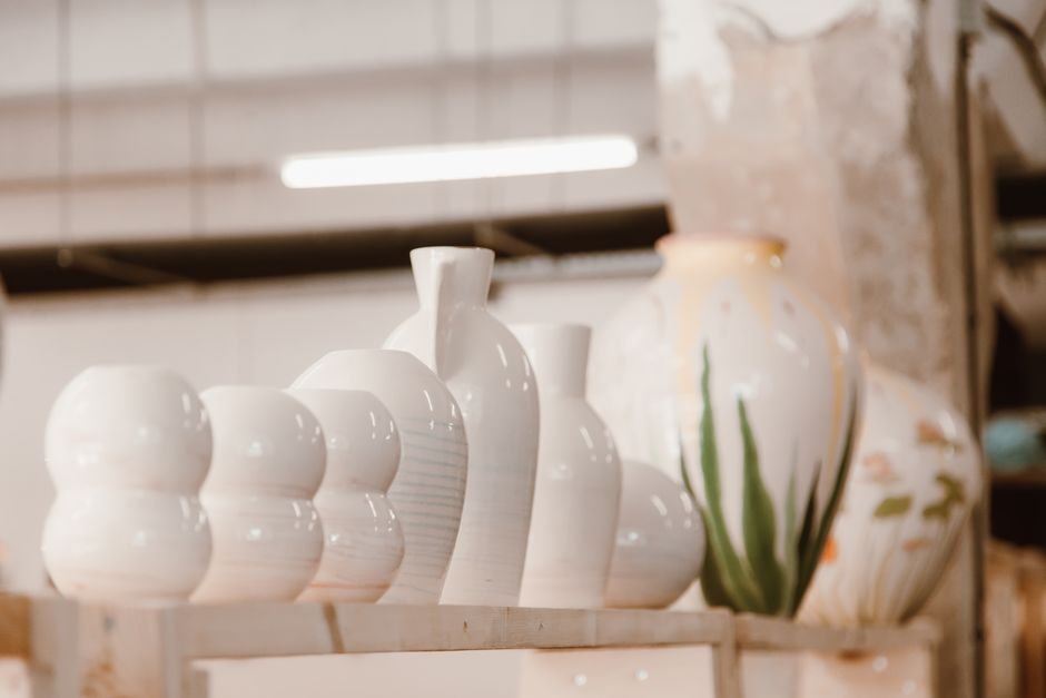 Glossy glazed ceramic bowls stacked on a studio shelf