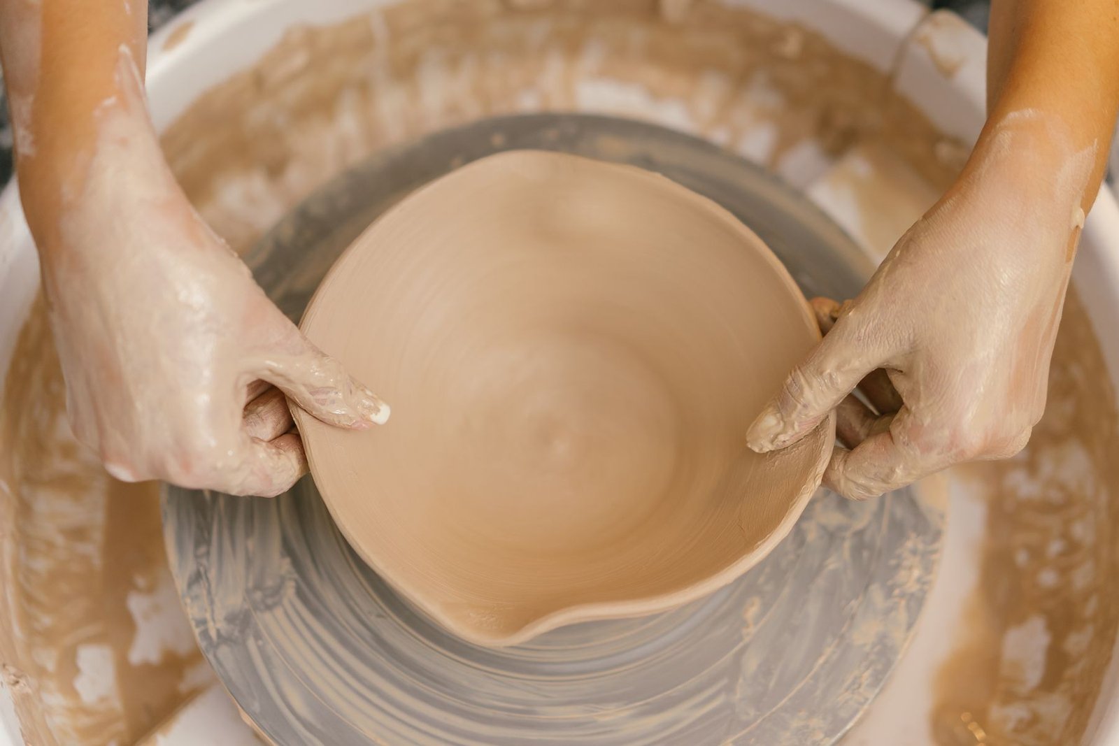Potter dipping a bowl into ceramic glaze