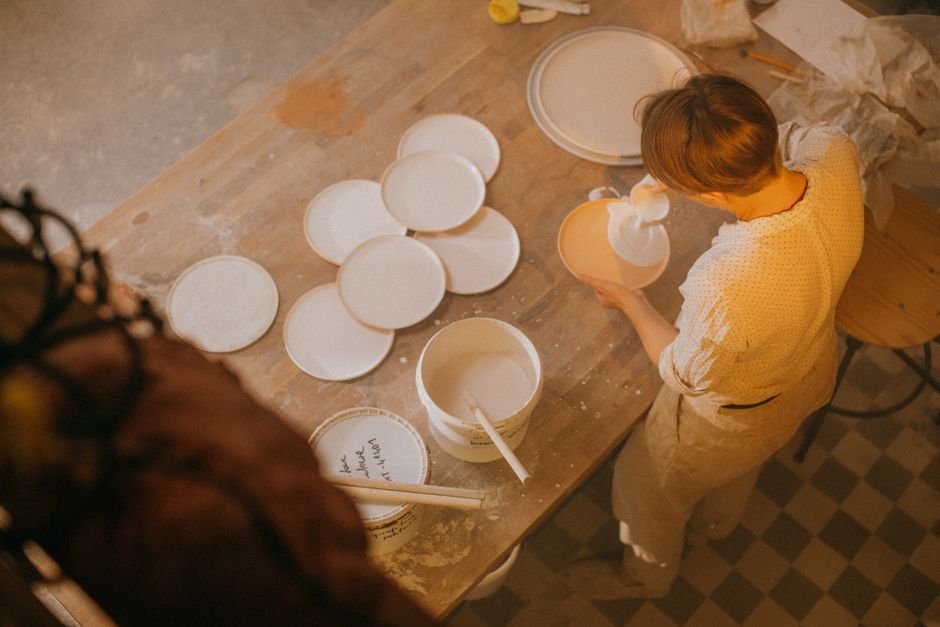 Ceramic artist applying glaze to a stoneware piece