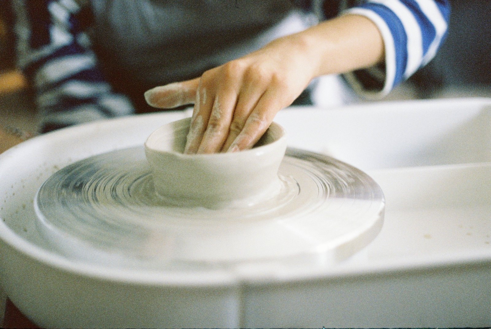Close up of a pottery wheel head and splash pan during throwing