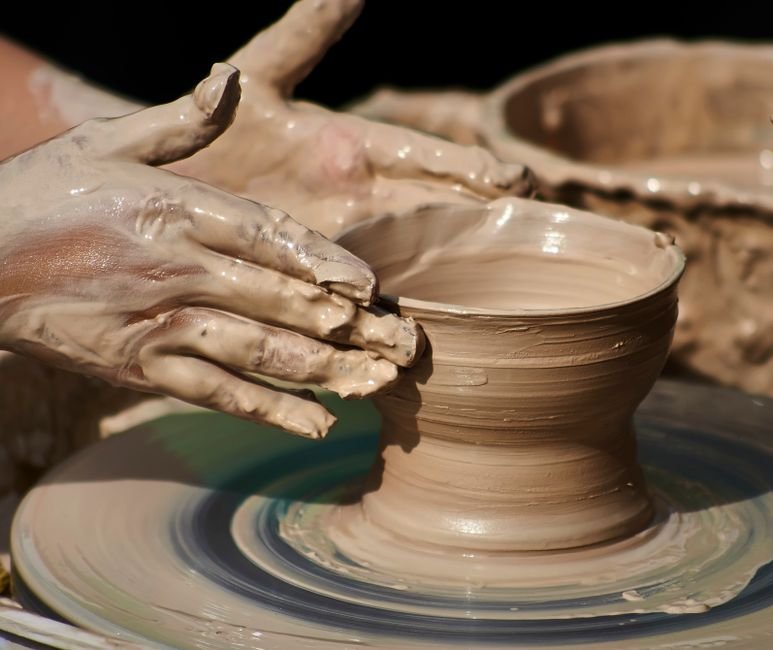Hands shaping pottery on a wheel during a pottery wheel class