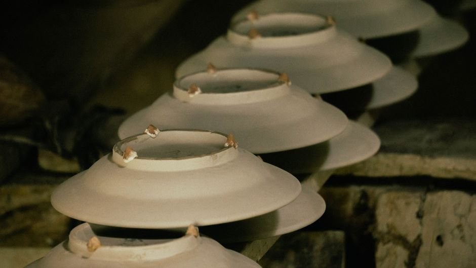 Stacked bowls in a pottery studio, similar to the unpainted ceramics offered for decorating