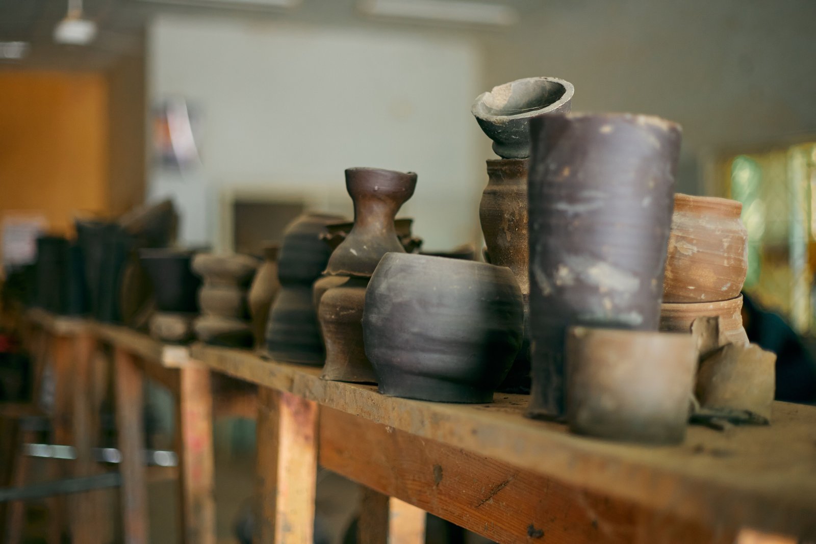 Greenware pottery pieces drying fully before kiln firing