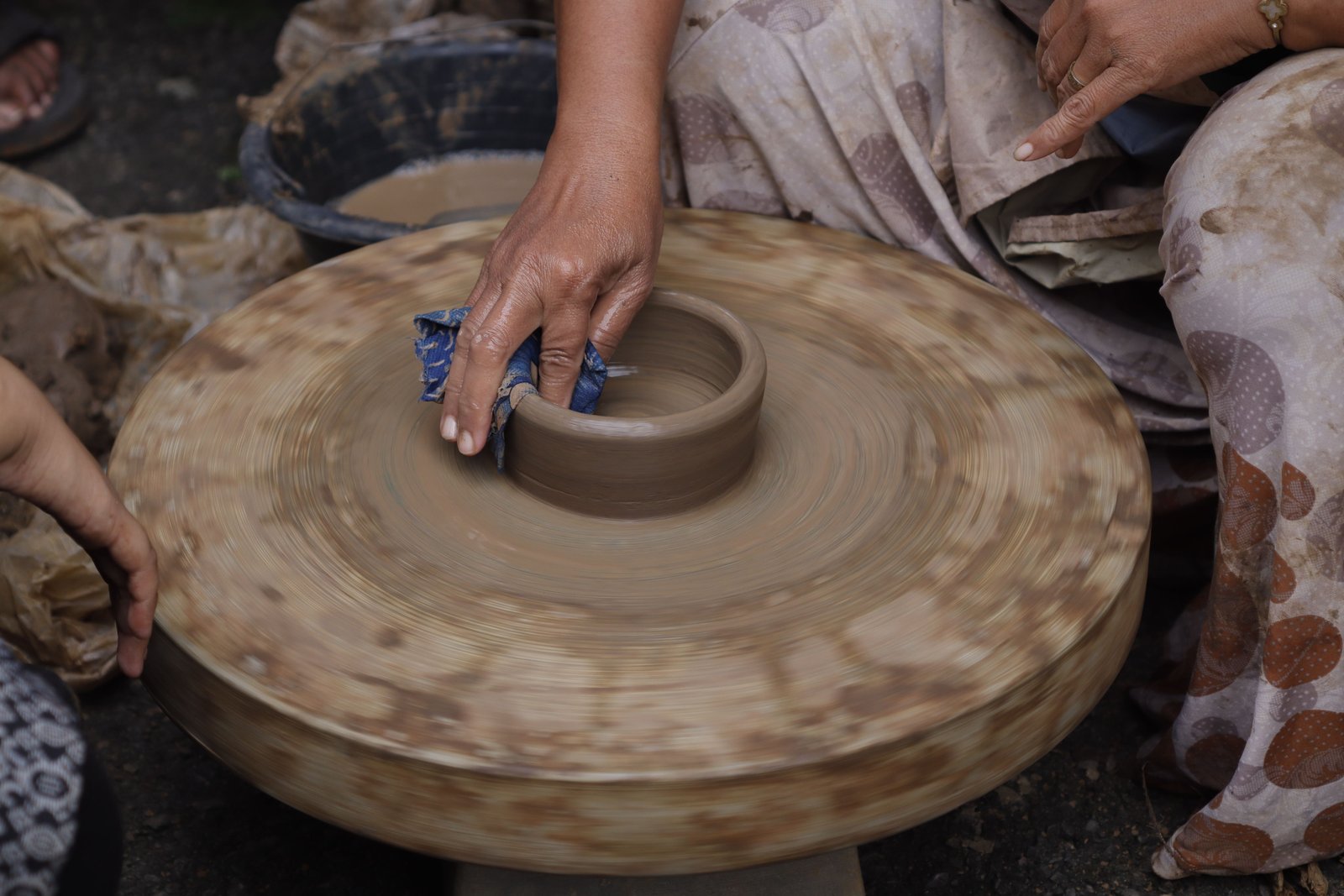 Pottery being shaped by hand on a spinning wheel