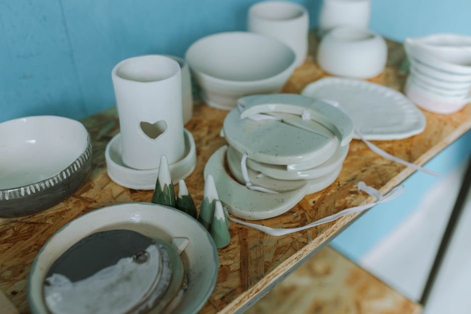 Handmade pottery on a wooden shelf, the kind of finished clay projects that follow drying and firing