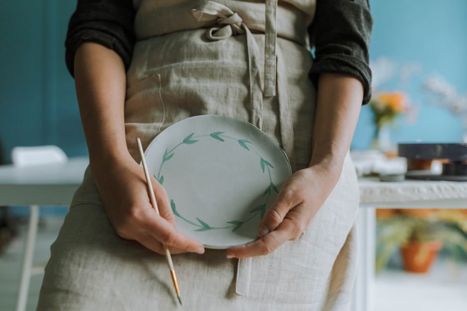 Hand painting a bisque ceramic piece with acrylic paint