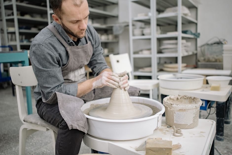 Potter comparing stoneware and porcelain pottery pieces in studio