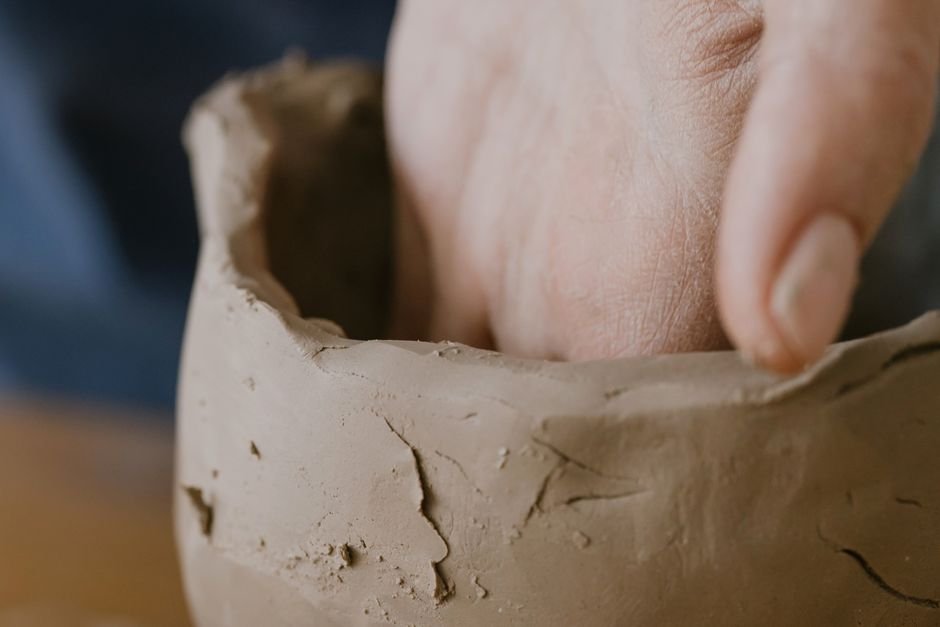 Hand shaping a clay pot, showing the pinch and coil hand building methods