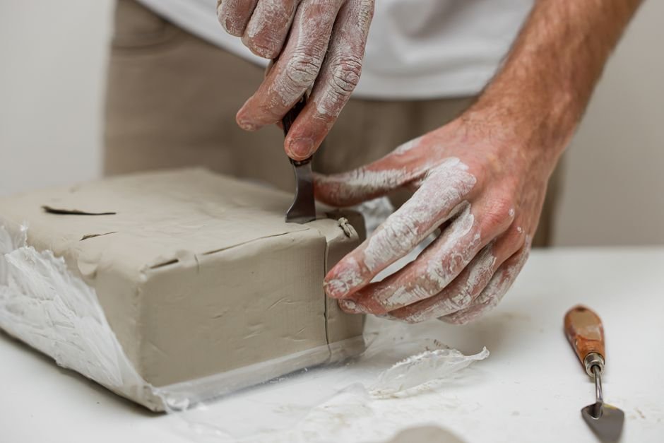 Ceramist shaping clay on a table while avoiding common hand building mistakes beginners make