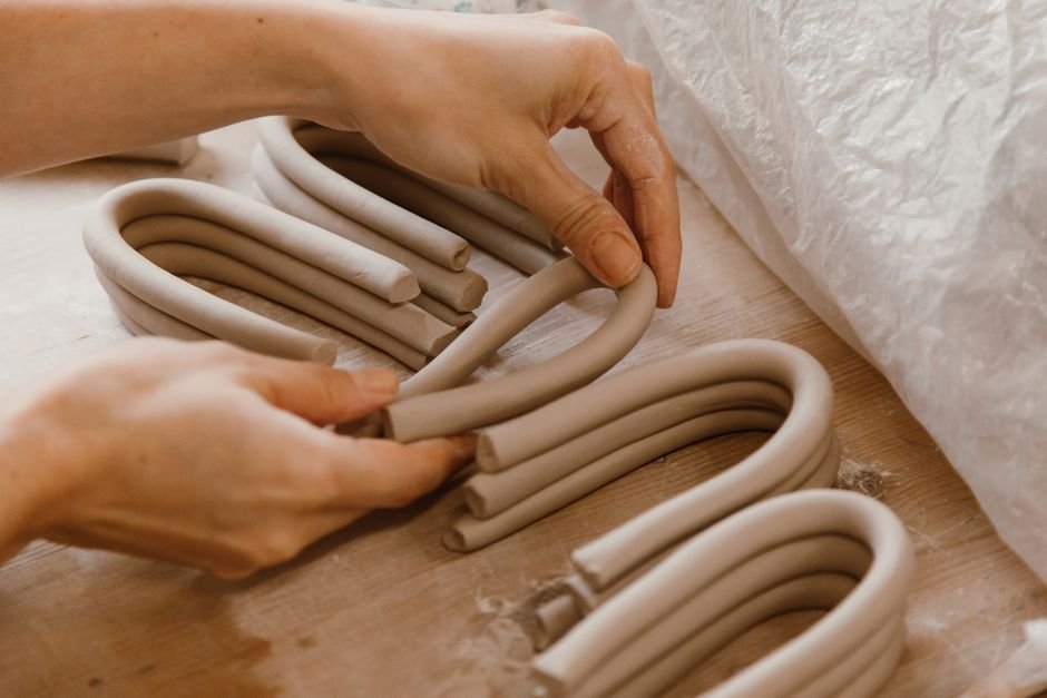 Hand building coiled clay pottery using ancient technique