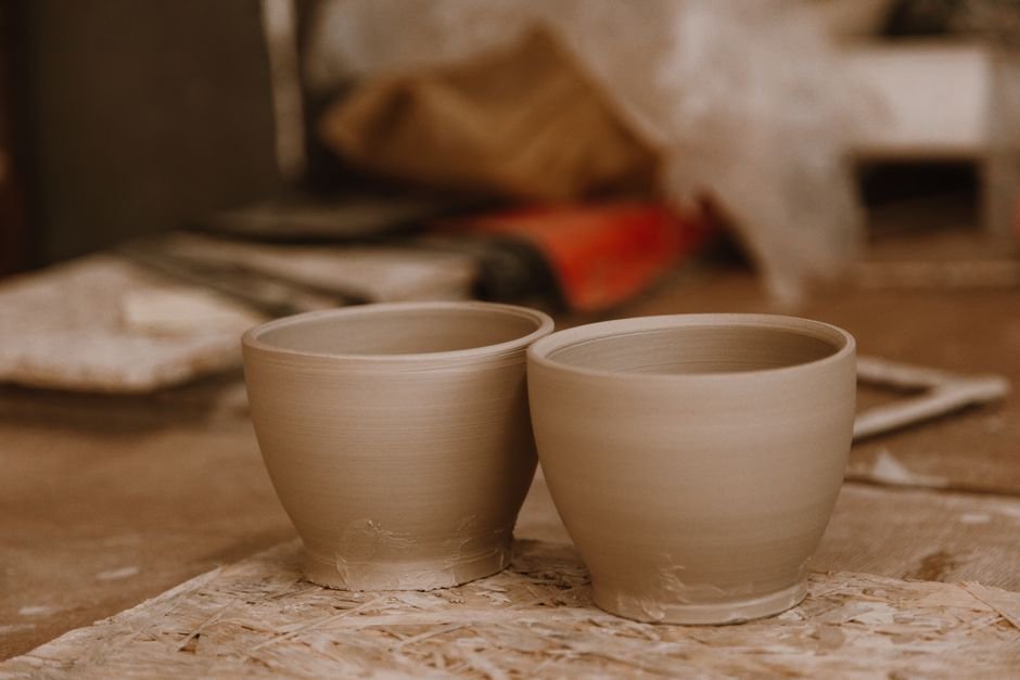 Two handmade clay pots in a workshop, the kind of result a first pottery wheel class can produce