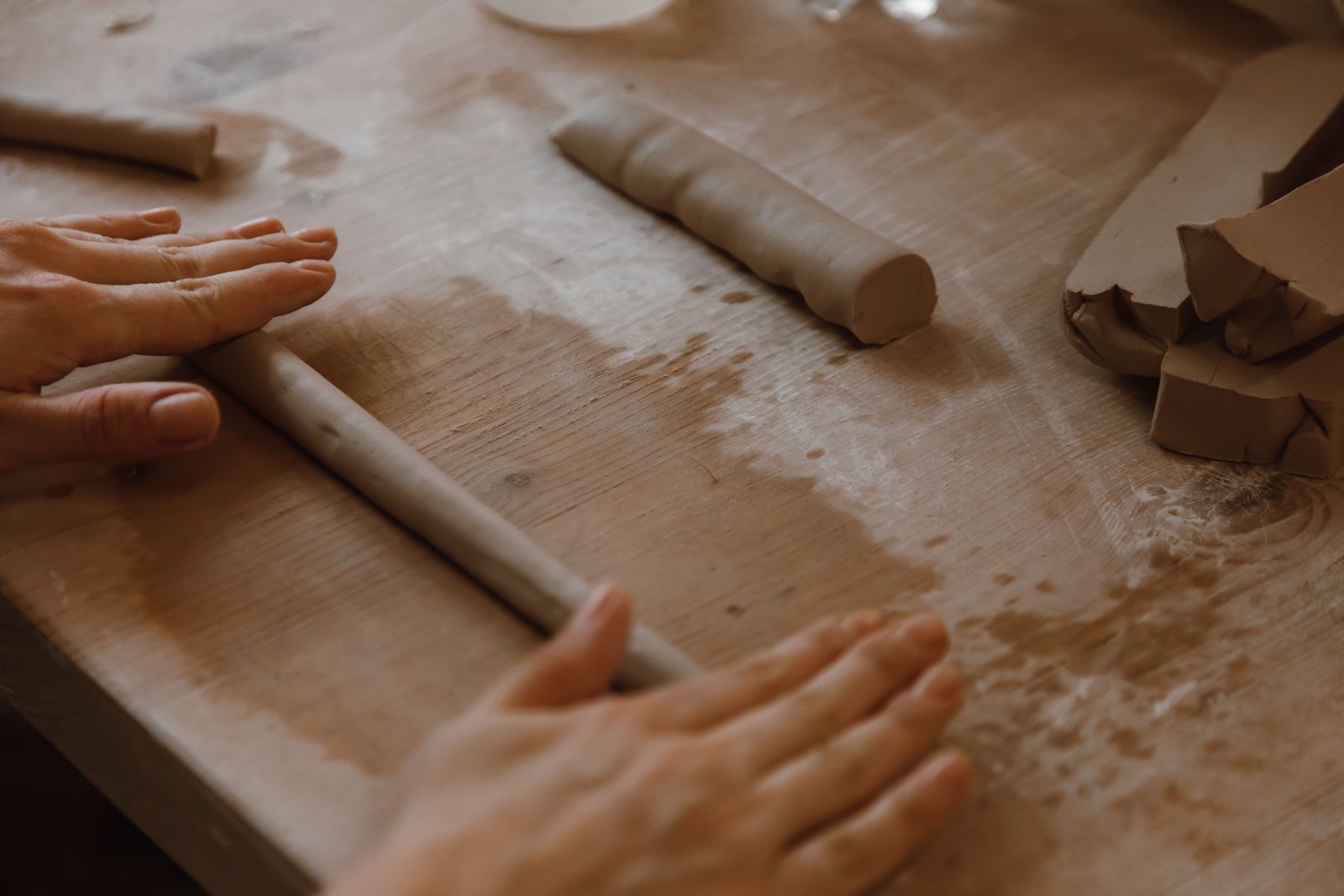 Wedging clay to adjust moisture consistency before shaping