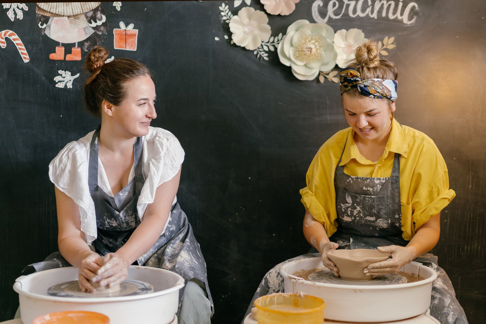 Relaxed studio atmosphere with people quietly working clay together