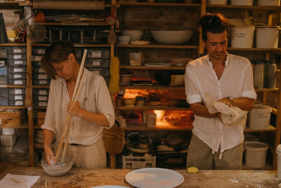 Two artists working together in a pottery studio, showing the community side of a shared studio