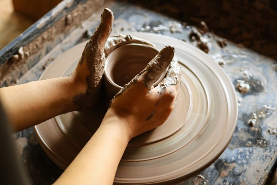 Close up of hands crafting pottery on a wheel, the heart of hand throwing pottery