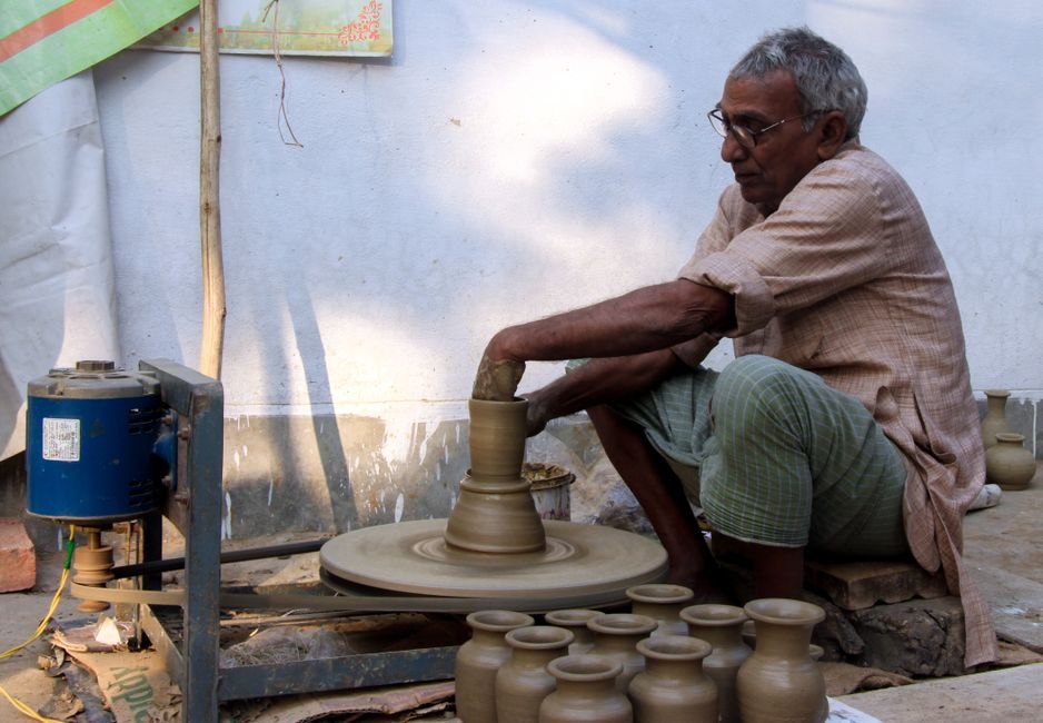 Elderly potter crafting on a spinning wheel, showing the skill built through hand throwing pottery