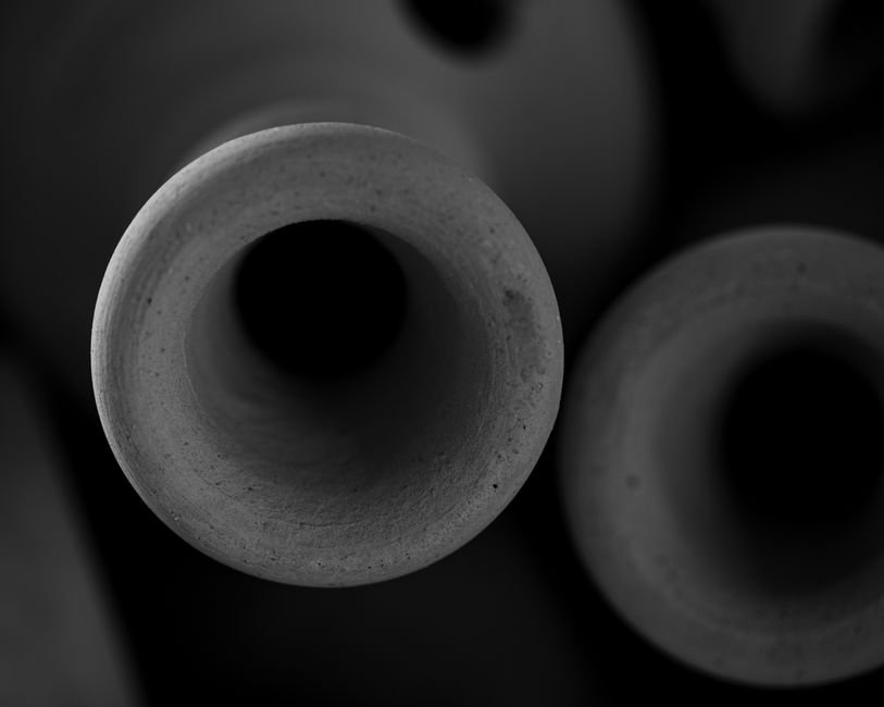 Black and white close up of textured ceramic vessels, echoing the smoky surfaces of raku firing