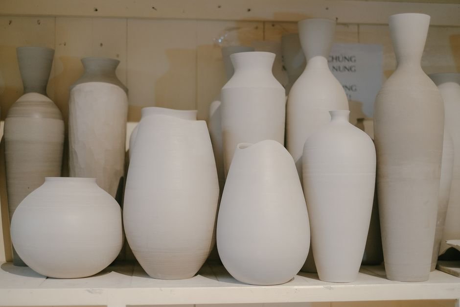 Handcrafted white ceramic vases on a shelf, showing ceramics interior design trends in a calm setting
