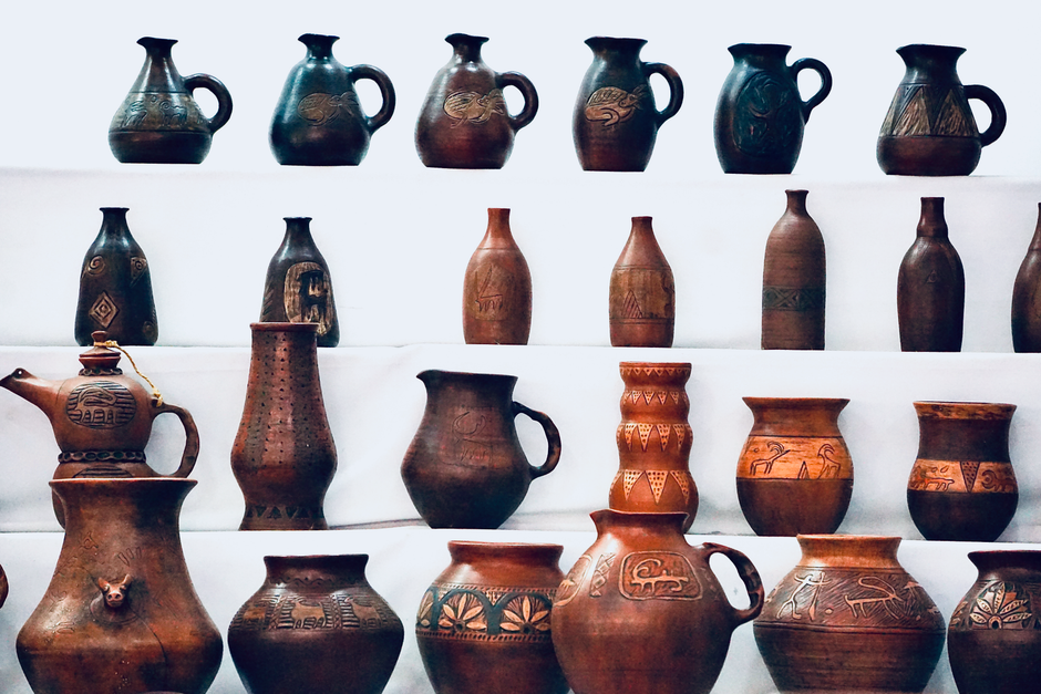 Handmade clay pottery displayed on museum shelves, a reminder of ceramics in art history