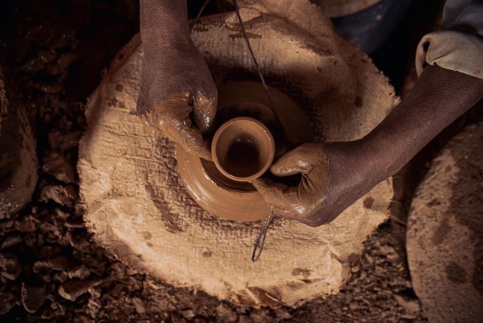 Close up of hands shaping clay on a pottery wheel, testing clay for pottery wheel work