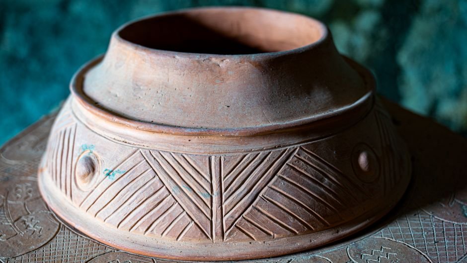 Decorative clay pot with raised and engraved surface patterns, related to the sprigging definition of applied relief