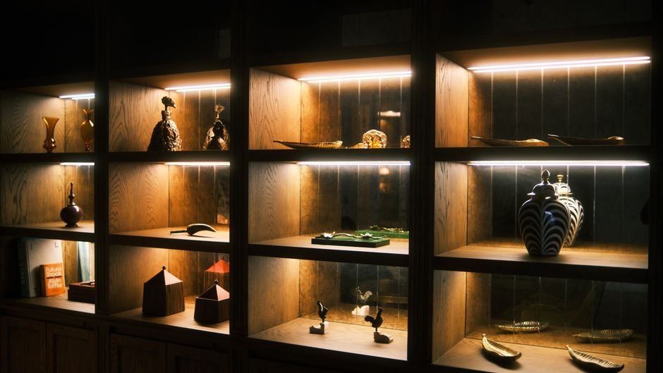 Wooden shelves displaying sculptural ceramics, an example of how abstract ceramic art is shown in a gallery