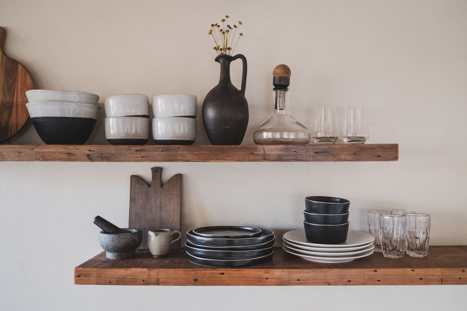 Ceramic bowls and glassware side by side on wooden shelves, showing porcelain glass differences