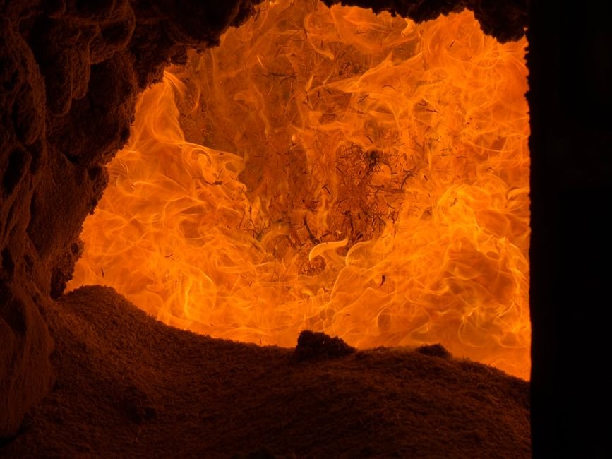 Intense orange flames inside a furnace, a reminder of the heat involved in raku firing