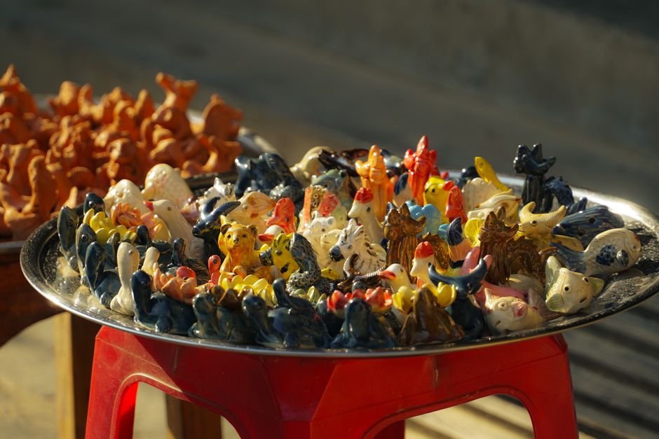 Colourful ceramic animal figurines on a tray, the kind of beginner easy clay models many people start with
