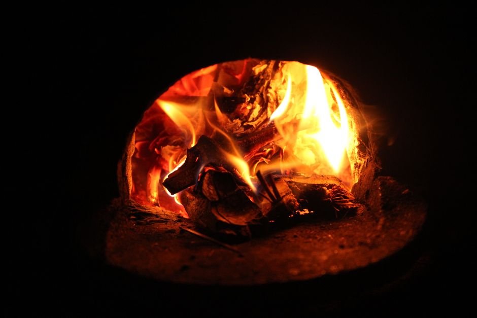 Roaring flames inside a traditional fuel fired kiln, one side of the electric kiln vs gas kiln choice