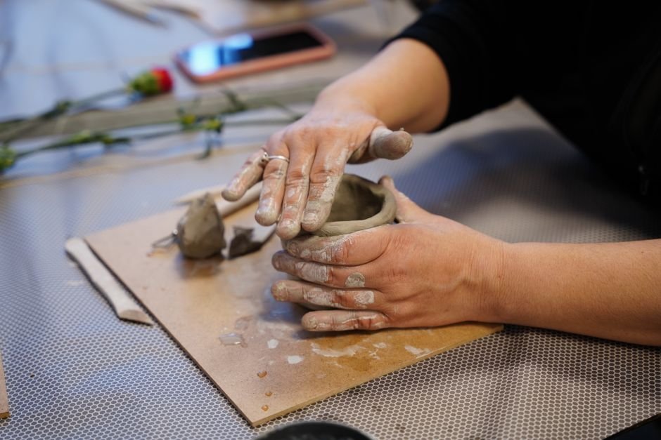 Hands shaping clay into a small pot, one of the classic beginner ceramics projects
